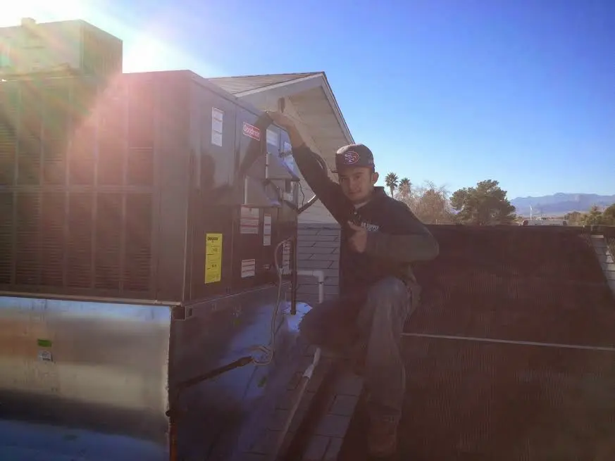 HVAC technician performing Air Duct Repair on a rooftop unit in East Foothills